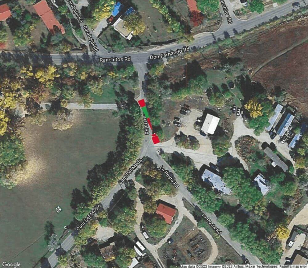 Overhead google maps view of residential streets in Taos, New Mexico. There are trees and houses and a small license plate reader camera icon overlaid that shows how it is monitoring traffic.